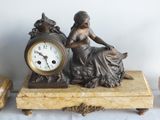 a statue of a woman sitting on top of a table next to a clock
