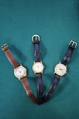 trois types de montres différents posés sur un fond vert