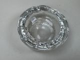a glass ashtray sitting on a white table