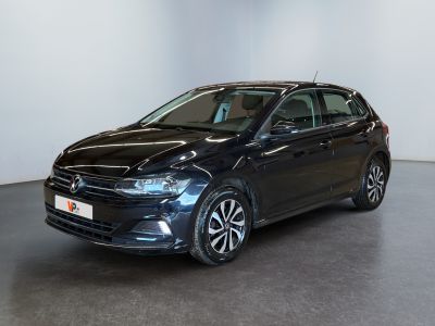 a black car is parked in a room with a white wall