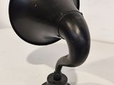 un vieux gramophone noir posé sur une surface blanche