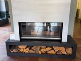 a fireplace with logs stacked on it in the middle of a room