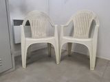 deux chaises en plastique blanches placées l'une à côté de l'autre