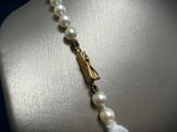 pearl necklace with gold clasp and white pearls on a mannequin mannequin