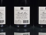three bottles of wine are lined up on a glass table