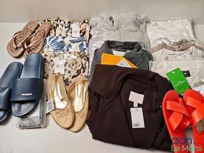 de nombreuses paires de chaussures et de vêtements disposés sur une table