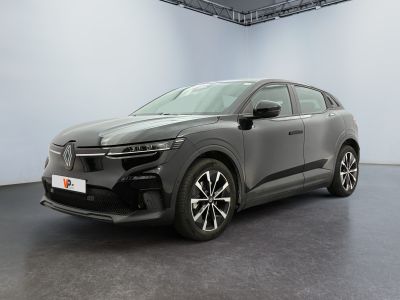 La voiture grise est garée dans une grande pièce au sol noir.