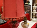 une table recouverte d'une nappe rouge, sur laquelle est posée une lampe