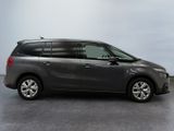 the grey minivan is parked in a large room