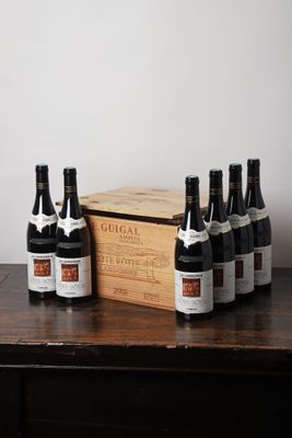 plusieurs bouteilles de vin posées sur une table à côté d'une caisse en bois