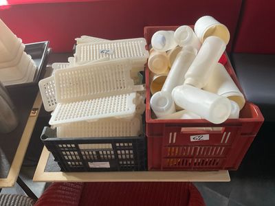 un panier rouge rempli d'objets en plastique posé sur une table