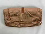 a close up of a gold purse on a white surface