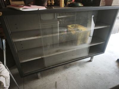 a black cabinet with a glass door in a garage