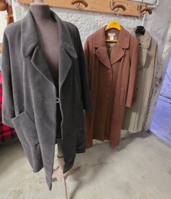 deux manteaux posés sur un présentoir à mannequin dans une pièce