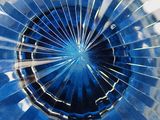 a close up view of a blue glass vase with a hole in it