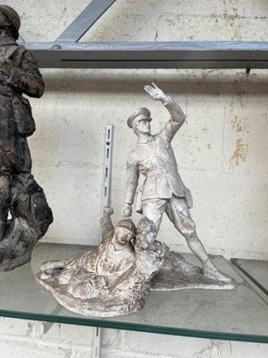 deux statues d'hommes posées sur une étagère dans une pièce