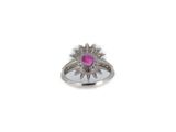 a close up of a ring with a pink stone surrounded by diamonds