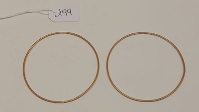 une paire de boucles d'oreilles en or sur fond blanc