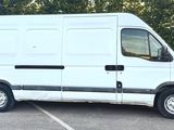 une camionnette blanche garée sur un parking avec des arbres en arrière-plan