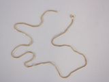 a picture of a gold necklace on a white surface