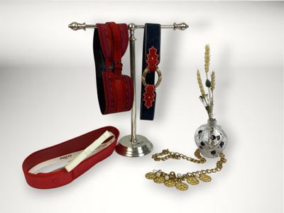 trois paires de chaussures et un collier posés sur un présentoir