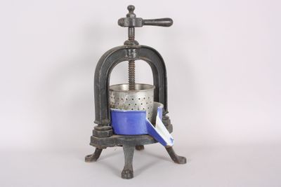 a small blue pot sitting on top of a metal stand
