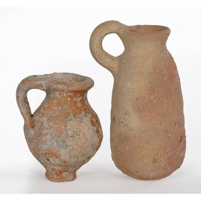 two vases sitting next to each other on a white surface