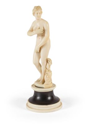 une figurine en ivoire représentant un garçon avec un chien, posée sur un socle