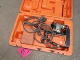 une mallette à outils orange posée par terre, contenant des câbles