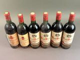 six bottles of wine are lined up in a row on a table