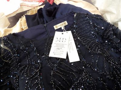 une robe noire à paillettes posée sur un lit