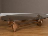 une table basse avec un plateau en verre posée sur un parquet