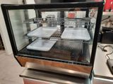 a glass display case with trays of food inside of it