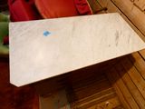 une table en marbre blanc sur laquelle est collé un autocollant bleu