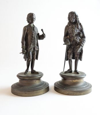paire de figurines en bronze représentant un homme et une femme avec des cannes