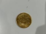 a close up of a gold coin with a shadow of a person