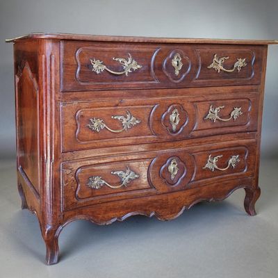 a wooden chest of drawers with gold decorations on it