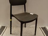 a black chair sitting on a striped rug in a room