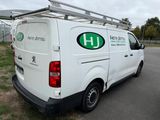 a white van parked in a parking lot with a ladder on the roof