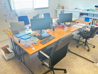 une image représentant un bureau avec deux ordinateurs de bureau et un ordinateur portable