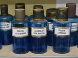 Plusieurs bouteilles contenant un liquide bleu sont alignées sur un comptoir