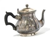 a silver teapot with a black handle on a white surface