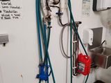 les tuyaux sont fixés au mur d'une salle de bains équipée d'un lavabo et d'un robinet