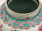 a white vase with a pink and blue design on it
