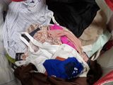 a basket full of clothes that is sitting on a bed