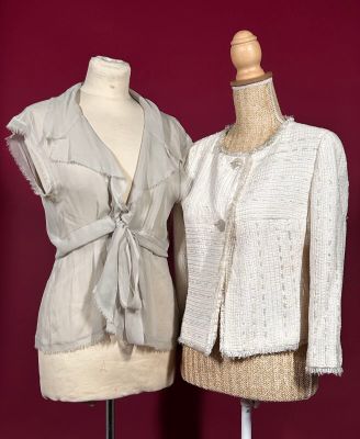 two mannequins with jackets on display on a stand