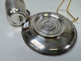 a silver cup and saucer sitting on a white table