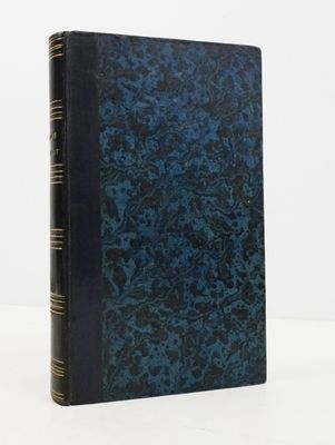 un livre bleu posé sur une table blanche, près d'un mur blanc