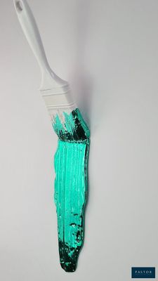 un pinceau blanc avec de la peinture verte sur une surface blanche