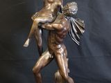bronze statue of a man holding a woman on his back